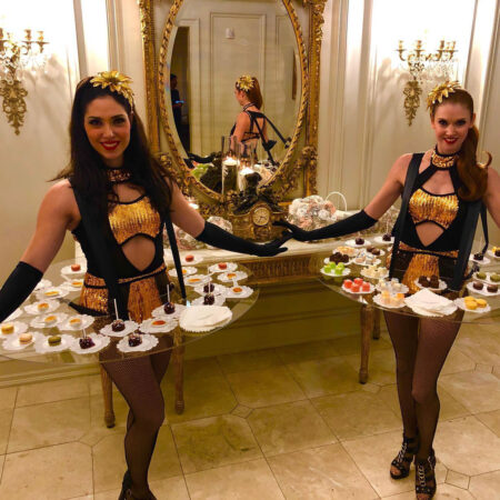 costumed women holding appetizers