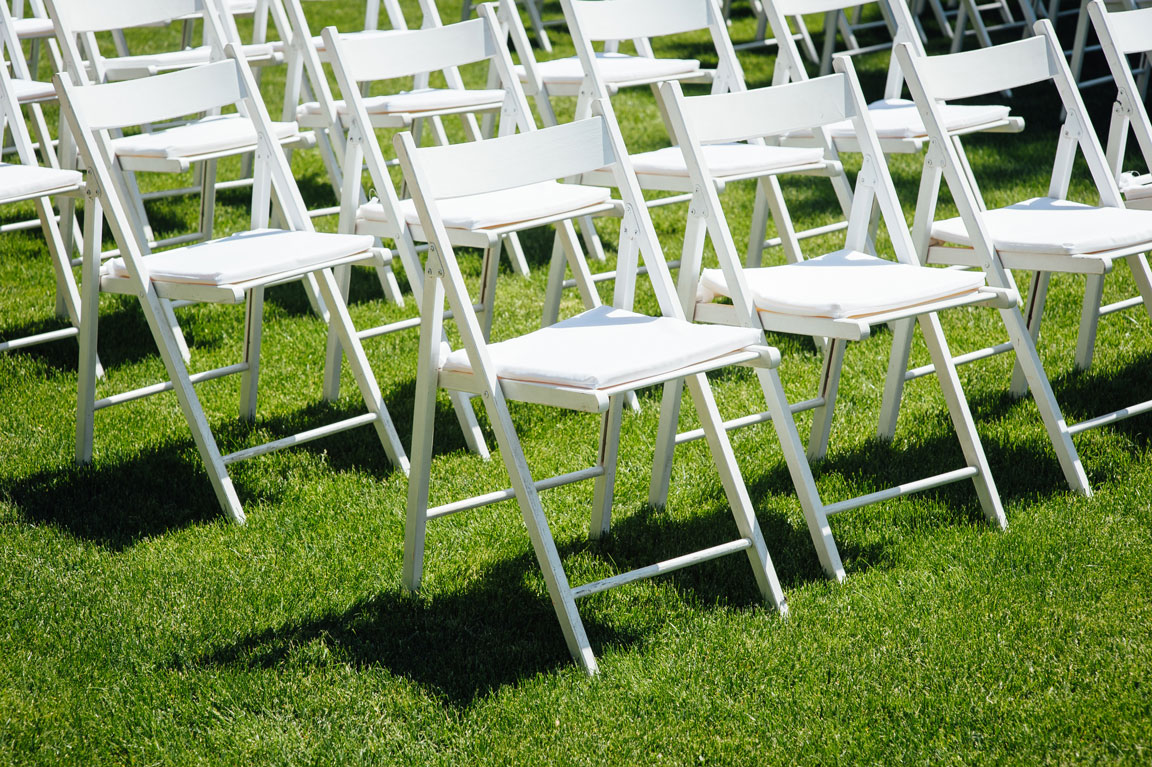 white folding chairs on a lawn