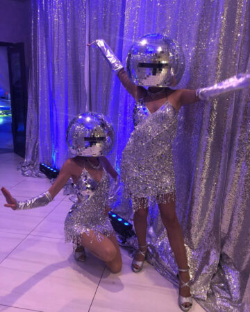 performers dressed in disco ball outfits
