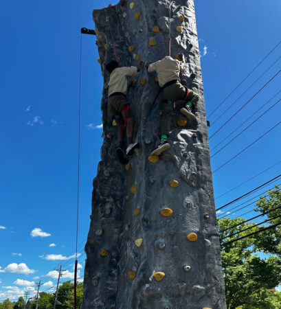 two people climbing rock wall