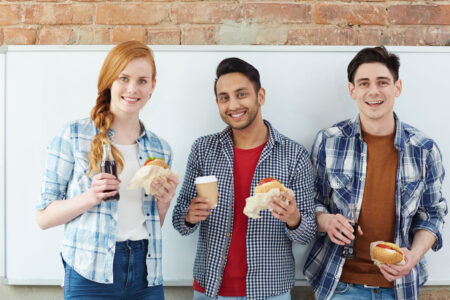 college students standing and eating food