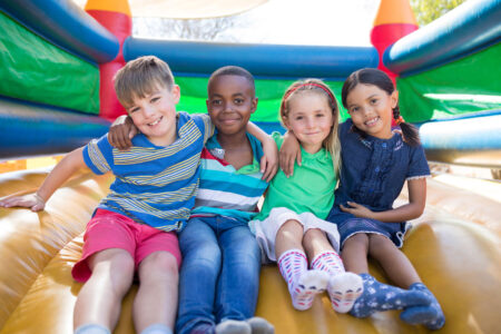 children sitting and smiling in bouncy house